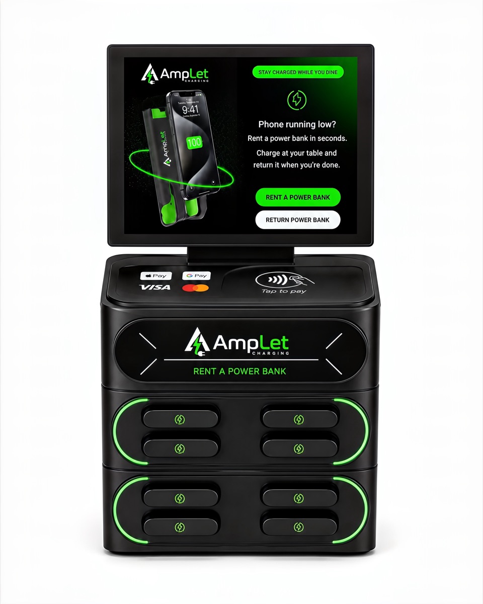 The AmpLet charging station seen from the front: a compact countertop dock with eight power-bank slots and a tap-to-pay screen